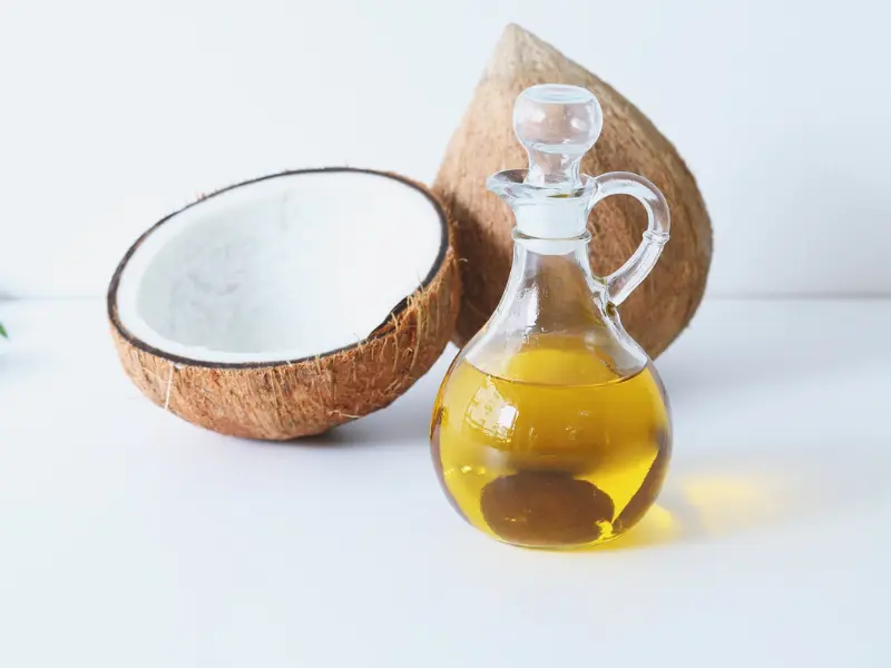 Coconut oil in a jar with a spoon, a natural remedy for nail moisture.
